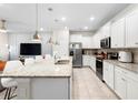 Bright kitchen features white cabinetry, granite counters, and an island with pendant lighting at 4314 Lana Ave, Davenport, FL 33897