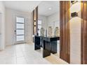 Stylish entryway with a decorative mirror, console table, and modern lighting at 8833 Cruden Bay Ct, Davenport, FL 33896