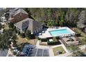 Aerial view of a neighborhood pool with lounge chairs, playground, and community building at 9575 Silver Buttonwood St, Orlando, FL 32832