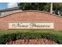 Brick community entrance sign surrounded by manicured landscaping and flower beds at 9575 Silver Buttonwood St, Orlando, FL 32832