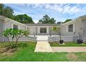 Inviting front porch with a white brick facade, plants, and a walkway, perfect for relaxing outdoors at 103 Longhorn Rd, Winter Park, FL 32792