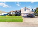 Lovely home featuring an attached garage, lush lawn, and stone facade details at 10642 Cloudview Dr, Orlando, FL 32825