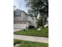 Two-story home with two-car garage, brick paver driveway, and lawn at 1122 Priory Cir, Winter Garden, FL 34787