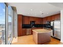 Modern kitchen with island, wooden cabinets, black backsplash and stainless steel appliances at 155 S Court Ave # 2008, Orlando, FL 32801