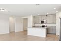 Spacious open-concept kitchen with island, gray cabinets, and stainless steel appliances at 1737 Forest Run Ln, Auburndale, FL 33823