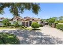 An estate home features a tile roof, a paved driveway, mature landscaping, and a private gate at 1741 Palmer Ave, Winter Park, FL 32789