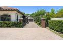 A stucco house has a tile roof, a brick entry gate, a private driveway, and mature landscaping at 1741 Palmer Ave, Winter Park, FL 32789
