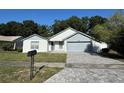 Charming single-Gathering home with a well-manicured front yard, brick driveway, and an attached two-car garage at 2009 Nottingdale Ln, Winter Park, FL 32792