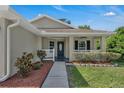 Inviting front porch with a tiled floor and decorative shrubs, perfect for relaxing outdoors at 2028 Donegan Pl, Orlando, FL 32826