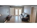 Inviting living room with doors to a private balcony, neutral walls, and wood-look tile at 204 E South St # 4056, Orlando, FL 32801