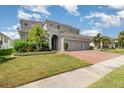 Beautiful home showcases a two-car garage, manicured lawn, and lovely curb appeal at 2061 Rush Bay Way, Orlando, FL 32824