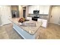 Bright kitchen with granite island, stainless steel appliances, and white cabinetry at 2450 Sweet Viburnum Way, Ocoee, FL 34761