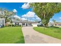 Charming single-story home with a long driveway, well-manicured lawn, and mature trees at 2460 Worthington Rd, Maitland, FL 32751