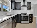 Modern kitchen with stainless steel appliances, black cabinetry, and quartz countertops at 2460 Worthington Rd, Maitland, FL 32751