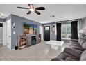 This living room has a ceiling fan, wall-mounted tv, tile floors, and modern furniture at 2471 Greenwood St, Deltona, FL 32738
