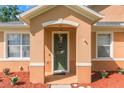 Close up of welcoming front porch with green door, decorative flower pots and mulch at 2619 Breezy Meadow Rd, Apopka, FL 32712