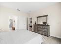Bright bedroom with a large dresser, neutral walls, and an ensuite bathroom, creating a relaxing retreat at 3007 Caneel St, Winter Haven, FL 33884