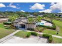Aerial view of the community pool, surrounded by palm trees, a clubhouse, and manicured grounds at 316 Primrose Dr, Davenport, FL 33837