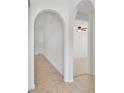 Bright hallway featuring tiled floor, neutral color palette, and arched doorways at 321 Thomasdale Ave, Haines City, FL 33844