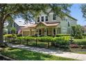 Beautiful two-story home with a manicured lawn, decorative fountain, and a welcoming front porch at 402 S Lake Victoria Cir, Deland, FL 32724