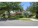 Attractive two-story home with a manicured lawn, decorative fountain, and mature trees at 402 S Lake Victoria Cir, Deland, FL 32724