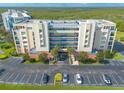 Aerial view of condominium building showing balconies, covered parking, and surrounding green space at 5300 S Atlantic Ave # 6-507, New Smyrna Beach, FL 32169