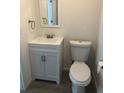 Bathroom featuring a toilet, vanity with white cabinetry, and modern fixtures, with neutral paint and wood look flooring at 647 Madison Ave, Daytona Beach, FL 32114