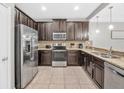 Modern kitchen features stainless steel appliances, granite countertops, and dark wood cabinets at 8215 Roseville Blvd, Davenport, FL 33896