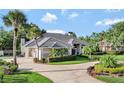 Stunning one-story home boasts a circular driveway and a manicured lawn with lush landscaping at 8713 S Bay Dr, Orlando, FL 32819