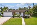 Inviting one-story residence boasts a manicured lawn, tidy landscaping, and an attached two-car garage at 896 Satin Leaf Cir, Ocoee, FL 34761