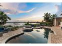 Relaxing backyard pool with a hot tub overlooking the lake and clear blue sky at 9724 Chestnut Ridge Dr, Windermere, FL 34786
