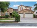 Charming two-story home featuring a stone facade, red tile roof, and lush tropical landscaping at 9736 Hatton Cir, Orlando, FL 32832