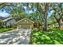 Charming home boasts a well-manicured lawn and mature trees shading the front yard and driveway at 1608 Victoria Way, Winter Garden, FL 34787
