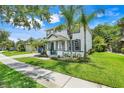 Inviting two-story home showcasing manicured landscaping and a cozy front porch with seating at 10252 Kristen Park Dr, Orlando, FL 32832