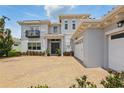 A picturesque home featuring an attached garage and paver driveway complemented by lush greenery at 108 Stanton Estates Cir, Winter Garden, FL 34787