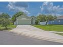 Exterior view of a single-story house with light green paint and a well-maintained lawn at 12020 Philbrook Ct, Orlando, FL 32825
