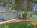 Well-maintained front yard with manicured flowerbeds and healthy green grass surrounding the entrance at 12020 Philbrook Ct, Orlando, FL 32825