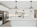 Spacious white kitchen featuring an island with quartz countertops, and stainless steel appliances at 13175 Telsen St # 40, Winter Garden, FL 34787