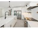 Elegant kitchen featuring stainless steel appliances, an island, and pendant lights at 13175 Telsen St # 40, Winter Garden, FL 34787
