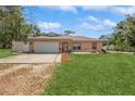 Inviting single-story home with a well-manicured lawn and a spacious driveway at 1395 Deland Ave, Orange City, FL 32763