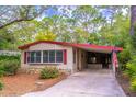 View of the home featuring mature landscaping, red shutters, and a long driveway at 149 E Plantation Blvd, Lake Mary, FL 32746