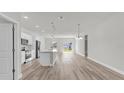 Open-concept living space featuring luxury vinyl flooring, island, and natural light at 15443 Sw 21St Ct, Ocala, FL 34473