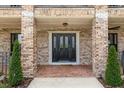 Inviting front porch with brick columns, decorative door, and charming landscaping, perfect for a warm welcome at 17524 Seidner Rd, Winter Garden, FL 34787