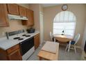 Kitchen showcasing oak cabinets, a white range, and a cozy breakfast nook with a window at 1754 Torrington Cir, Longwood, FL 32750