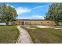 Charming one-story home with a stone walkway leading to the front door, showcasing a well-maintained lawn at 181 W Minnehaha Ave, Clermont, FL 34711