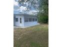 Enclosed sunroom with multiple windows and a door to the backyard, surrounded by lush greenery at 2233 N Normandy Blvd, Deltona, FL 32725