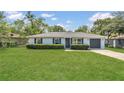 Well-maintained single-story house with a neatly manicured front lawn, dark shutters, and a one car garage at 250 Hickory Ave, Orange City, FL 32763