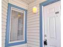 Close-up of the front door with window showing the exterior siding of the unit at 2536 Woodgate Blvd # 202, Orlando, FL 32822