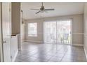 Bright living room with tile floors, ceiling fan, and sliding glass doors leading to a patio at 2536 Woodgate Blvd # 202, Orlando, FL 32822