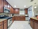 Well-equipped kitchen with stainless steel appliances, granite countertops, and dark wood cabinets at 293 Drosdick Dr, Casselberry, FL 32707